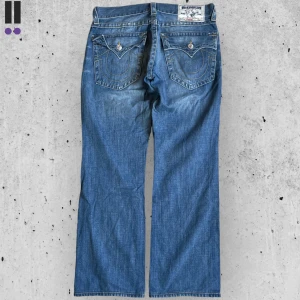 True religion jeans #704 - True Religion jeans i model Straight 💜 Tag 34W 💜Midja (rakt över) 46cm 💜 Innerben 82cm 💜 Ytterben 106cm 💜 Benöppning 23cm 💜 Hålen är täckta bakom 💜Våra mått blir W=36, L=32 💜 Men jämför alltid måtten💜704