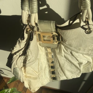 Vintage guess väska - Äldre väska från Guess! Guldiga detaljer. Förvänta dig att väskan flagnar här och var från skinnet. Kom privat för fler bilder. Säljs pga skicket ☀️