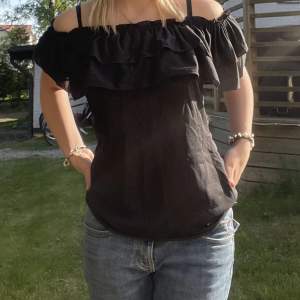 Superfin svart off shoulder tröja med volanger har knappt används! Perfekt till sommaren!  Storlek 38 men passar också bra på en 36!💗☀️