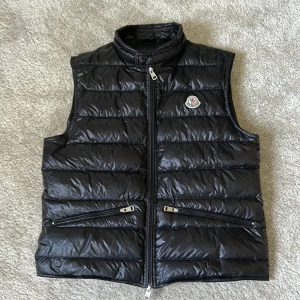 Moncler väst - Jag säljer min moncler väst pga av att den tyvärr har blivit för liten för mig. Inköpt förra året. Storlek 2. Ny pris: 7 780kr Jag säljer för 4000 kr.