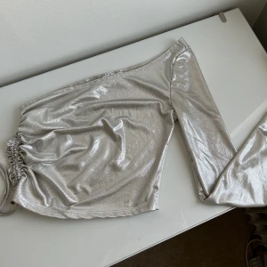 Enarmad Festtopp - glittrig nästan chrome aktig festtopp köpt för nyår 2022 och använts endast 2 gånger