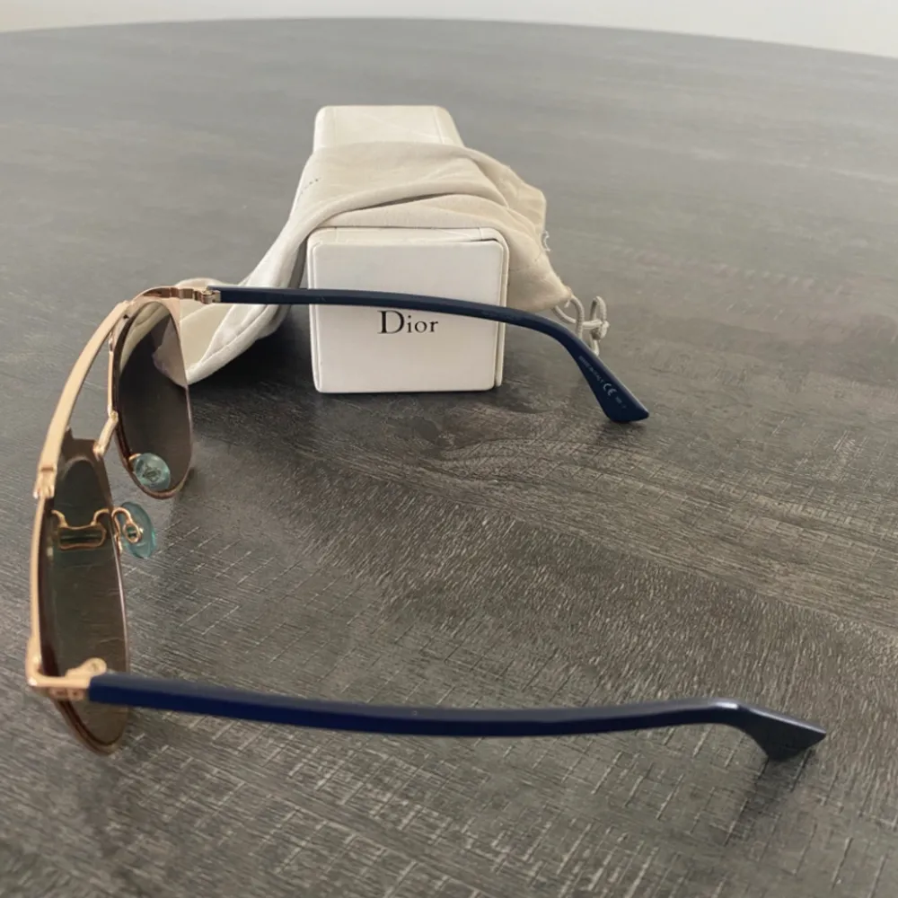  Christian Dior 'Reflected' solglasögon med guldmetallram och mörkblå skalmar. Guld speglade rosa linser. Har använts få gånger och säljs då det inte kommer till en användning. Inköpta på NK i Göteborg för cirka 4000kr . Accessoarer.