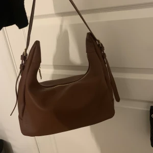 Väska - En jätte fin brun väska som man får plats med så oerhört mycket saker i den är jätte rymlig och helt oanvänd. 