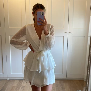 Vit sommarklänning - Vit, supersöt sommarklänning från Gina Tricot. Använd 1 gång på midsommar så den är i fint skick.  Finns en hasp för att knäppa klänningen om man inte vill ha den lika urringad som på bild. 🤍  Storleken är justerbar med bandet i midjan. 