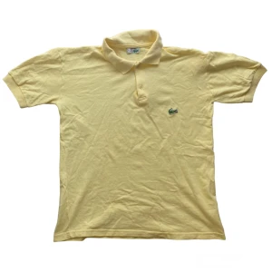 Vintage Lacoste Tröja - Vintage Lacoste Piké i storlek XL men passar som en Large. I fin ljusgul färg som blir perfekt inför sommaren. Gjord i Frankrike och i toppen skick.
