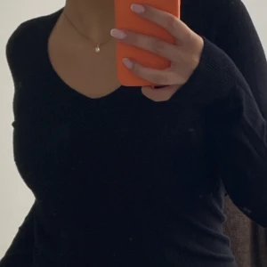 Svart långärmad tröja med liten slits  - Används inte längre.