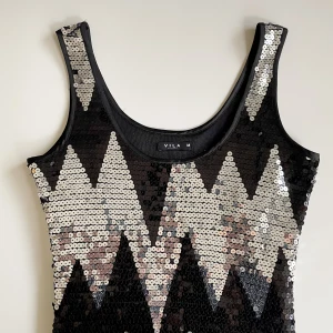 Klänning - Supersnygg Vila klänning i asbra skick som jag endast säljer då den är för tight över bysten på mig! Svartsilvrigt blixtmönster och går till halva låret i längd⭐️❤️nypris 699kr! (säljer en nästan likadan fast i S om man är intresserad)