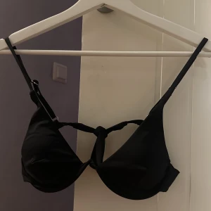 Bikini - Säljer denna svarta bikini med bygel som formar bysten. Inte vadderad, men den är väldigt snygg på. Knyts baktill. 