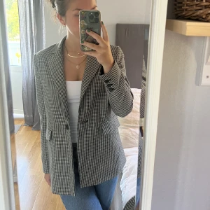 Rutig blazer - Superfin och rejäl kavaj/blazer från Mango. Är svart, beige, brunt rutig som är så fint till hösten. Fickorna i sidan är äkta. Är i storleken S, men lite liten i storleken. Kan tex inte ha en stor tjock stickad tröja under. Använd få gånger, är som ny.