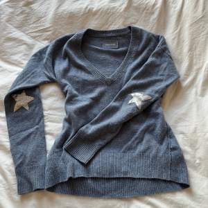 Ljusblå v-ringad tröja från zadig & voltaire med stjärnor på ärmarna i silver metallic. Använd fåtal gånger! Går inte att få tag på längre! 
