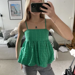 Grönt linne - Jättefint grönt linne med blommönster! Justerbara band och resår i ryggen! Jättebra skick💗