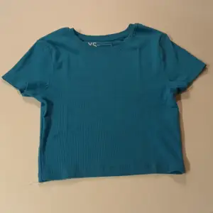 En blå jättefin men tyvärr förliten ribbad t-shirt ifrån new yorker. Strl: XS. Enligt mig väldigt kort.