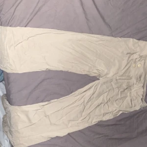 Lågmidjade Bootcut kostymbyxor  - Byxorna är lågmidjade bootcut i färgen beige. Dom är från h&m och finns inte längre kvar i butik eller online. Storlek xs