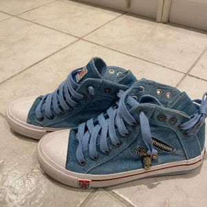 Sneakers med detaljer - Supercoola sneakers i jeansmaterial med silvriga detaljer. Skorna är i princip i nyskick, de är i storlek 38 men skulle nog också passa 37 bra