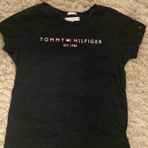 Tommy Hilfiger - Säljer Tommy hilfiger t-shirt då den är för liten men den är i jättebra skick och nästan aldrig använd storlek 176 