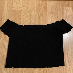 Off shoulder topp - Svart off shoulder topp, lite stor vid axlarna, okej skick.