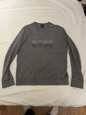 Hugo boss tröja - En fin hugo boss tröja som används en del men är i fint skick. De finns en liten defekt på höger armbåge men ( se på bild 2). Annars är tröjan jättefin. Om ni har frågor och funderingar är de bara att skriva.