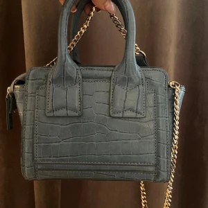 Zara väska  - Liten jätte snygg väska från zara. Kommer med band men som går att ta bort. Det finns en sminkfläck inuti väskan, annars är den som ny😊