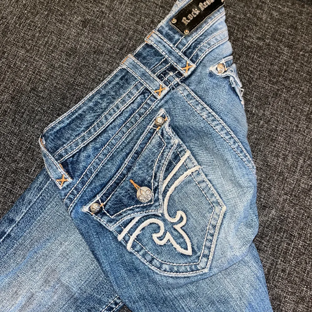 Lågmidjade jeans från rock Revival.  Fint skick men som ni ser på bild 3 så har den tappat en bokstav men inget man tänker på. Bootcut Strl W28. Jeans & Byxor.
