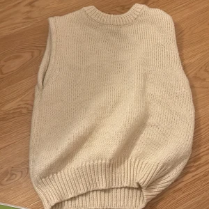 Stickad väst - En vitt/beige stickad vest. Knappt använd och inga tecken på användning. Säljer för inte min stil