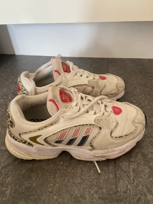 Adidas sneakers stl 36 - Kommer se till att tvätta iordning de innan de skickas iväg. Sneakers från Adidas, breda och sköna. Röd, guldiga detaljer med leopard. Storlek 36. Normala i storleken. 