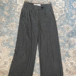 Randiga gråa kostymbyxor - Ett par gråakostymbyxor med små vita ränder. Dessa byxor är lite kortare i modellen💌