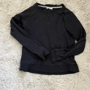 En grå/svart tröja som inte kommer till användning. Väl använd och storleken har suddats ut men gissar på xs.