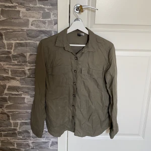Olivfärgad skjorta  - Fin grön skjorta i bra skick.  Köpt för 399kr, säljer för 49kr.