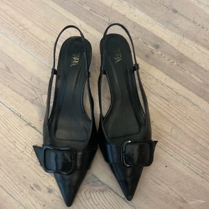 KLACKAR - Svarta Zara klackar i lack med snyggt spänne. Bra skick! 