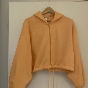 En kortare zip hoodie som går att dra åt i midjan
