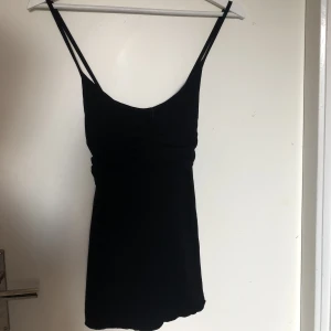 Festligt linne - Säljer detta lite festligare linne med korsade band i ryggen. Det är köpt från  D&G och det står att storleken är en xxl men den sitter som en M. Den är superfin och går att både klä upp och ner pga den lilla detaljen med korsade band i ryggen!