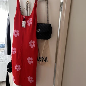 Långklänning - Stickad klänning från H&M. Med stora rosa blommor. 🌸 Går till smalbenen på mig som är 178 cm. Aldrig använd med prislapp kvar. 😇🤩