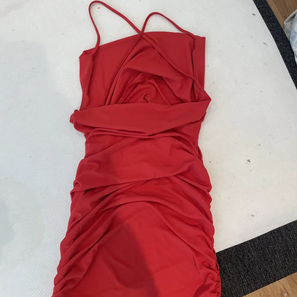En röd klänning från zara i storlek S.  Sitter tajt mot kroppen och axelbanden korsar sig fint i ryggen. Använd 1 gång. Tvättas innan den skickas/hämtas . Klänningar.