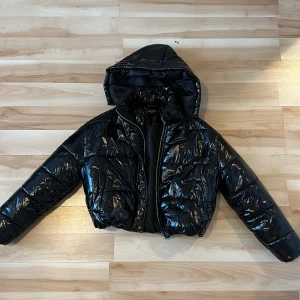 Puffer jacka  - Kort, svart glansig puffer jacka. Väldigt fin men tyvärr inte min still längre :)