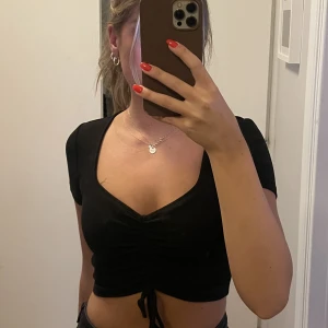 Croppad T-shirt med knytdetalj  - T-shirt från monki som säljs då den aldrig kommer till använding! Bra skick i strl S🥰