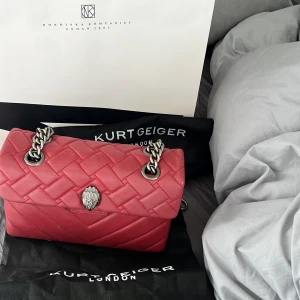 Kurt Geiger London Väska - säljer Kurt Geiger London Väska i denna älsklings röda fägen med silver detaljer samt kedja. Sjukt praktiskt samt stilren  handväska om du behöver få plats med saker men samtidigt ha handväska. Og pris: 2755, dustbags tillkommer vid köp. Condition 10/10❤️ 