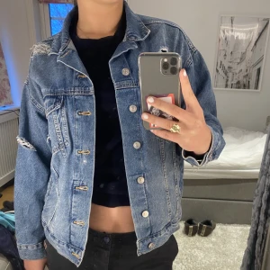 jeansjacka - Jeansjacka med jätte snygga slitningar i storlek xs! Modellen på jackan är oversized och sitter därför som en M