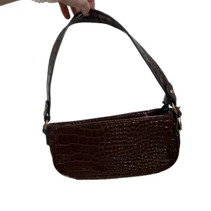 Brun handväska! - Supersöt brun handväska med guldiga detaljer & dragkedja i ormskinnsimitation🤩 Bredd: 29cm Höjd: 16cm Checka gärna min sida där jag säljer andra väskor 😌