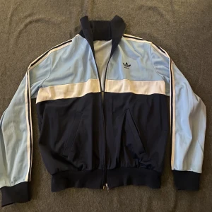 Adidas jacka  - En jättefin y2k jacka från adidas🫶🏼 Lite sliten men överlag fint skick. Oklart vilken storlek men sitter fint oversized på mig som brukar ha storlek S.  Köp via appen