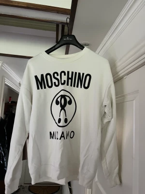 Moschino  - Tröja, stl. L, Herr Säljer denna fina moschino tröja. Storlek L men passar även M. Ny pris 3000kr. Säljs nu för 800. Priset kan diskuteras  800 kr