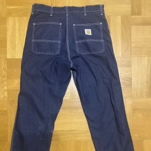 Carhartt jeans  - Mörkblå Carhart jeans i storlek 32 som är knappt använda.   Pris kan diskuteras vid snabbaffär. Hör av er vid frågor eller funderingar!  