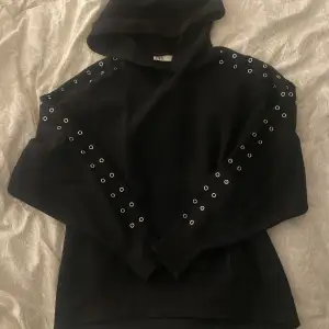 Jättefin svart hoodie med detaljer längst ärmarna. Jätteskön, ganska tunt material. Lite noprig för välanvänd men inget som stör och fint skick annars.