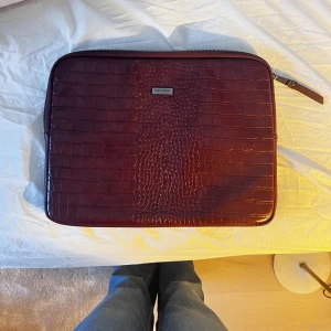 Datorfodral  - Snyggt vinrött datorfodral ifrån Don Donna. Får plats med dator och böcker! 