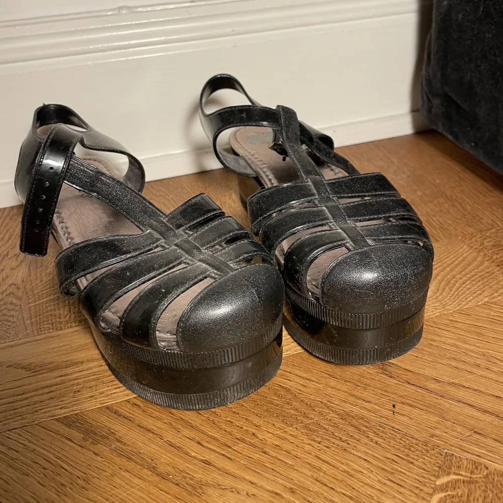 Svarta platå sandaler typ. Sulan är 4 cm där fram och 6 där bak. Inte använda särskilt mycket men ena är lite sliten på insidan av sulan. Jag kan mötas upp nära Mariatorget eller posta. . Kengät.
