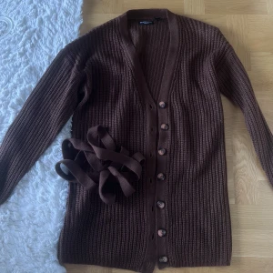 Brun/Röda kofta storlek XS - Säljer denna brun/röda kofta från märket Brave Soul i storlek XS. Koftan är i väldigt bra skick och är endast använd 1 gång. Medföljer även ett snöre som man kan sätta runt midjan. 