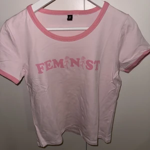T-shirt med tryck - Tajt ljusrosa tisha med helskönt tryck på😜😜 osäker på strl men skulle spontant gissa på M! Bra skick, använd enstaka gång