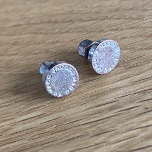 Marc Jacobs örhängen  - Runda silverörhängen i märket MJ.  Plopp bakom något avskavda. Har polerats med silverputs. 