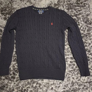 Raulph Lauren tröja - Säljer denna stickade Polo Raulph Lauren tröjan. Den är i nyskick och nypriset ligger på ungefär 1400 kr. Storleken är 14y men skulle säga att den är Small. Kom privat för mer info/bilder 