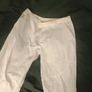 Vita byxor i ”prassel” tyg, har dragkedjor längst ner vid benen och är vida✨ (Passar för folk runt 170cm)