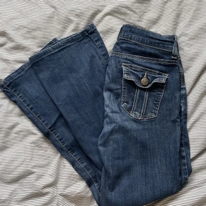 Lågmidjade Bootcut jeans  -  lågmidjade jeans med så fina fickor och detaljer. De är lite stora på mig som vanligtvis bär XS, så skulle säga säga att de är en storlek S. Midjemått: 36 innerbenslängd: 70. Vill du köpa är det bara att trycka på ”köp nu”